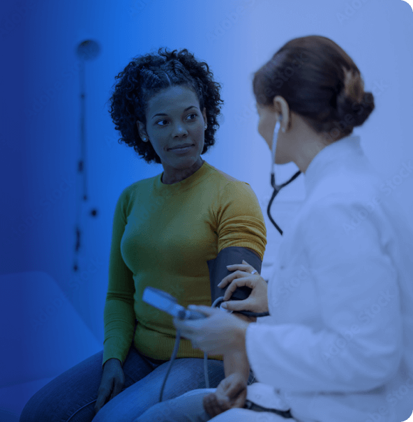 A doctor takes a woman's blood pressure.